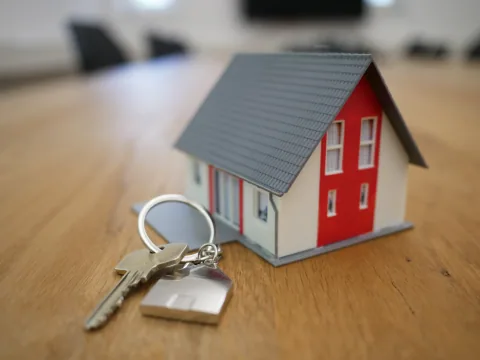 A couple holding keys in front of a new front door